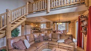 A spacious living area with a large L-shaped leather couch, a wooden coffee table, and a wooden staircase leading to an upper level. - Fish, Hike & Explore: Prescott Cabin w/ Grill! (Prescott)