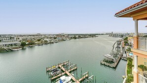 Un port de plaisance avec des bateaux amarrés, une jetée s’avançant dans l’eau et des bâtiments le long du quai.