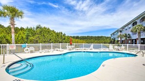 A swimming pool with a white fence, lounge chairs, and a palm tree. - Little River Condo w/ Pool < 6 Mi to Beach! (Little River)