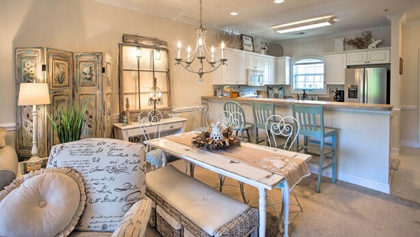 A dining area with a chandelier, a table with a floral centerpiece, and a bench. - Little River Condo w/ Pool < 6 Mi to Beach! (Little River)