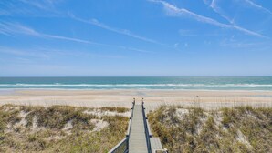A wooden boardwalk leading to a beach with sand dunes and ocean views. - Beachfront Oasis w/ 2 Large Decks, BBQ & Views! (Holly Ridge)