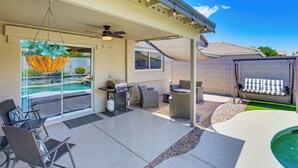 A covered patio with a pool, outdoor furniture, and a grill area. - Private Pool & Patio: Home in Surprise! (Surprise)