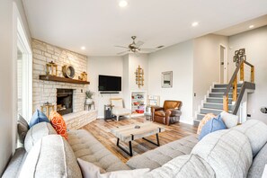 Cozy living room with a fireplace, comfortable seating, and a staircase leading upstairs.