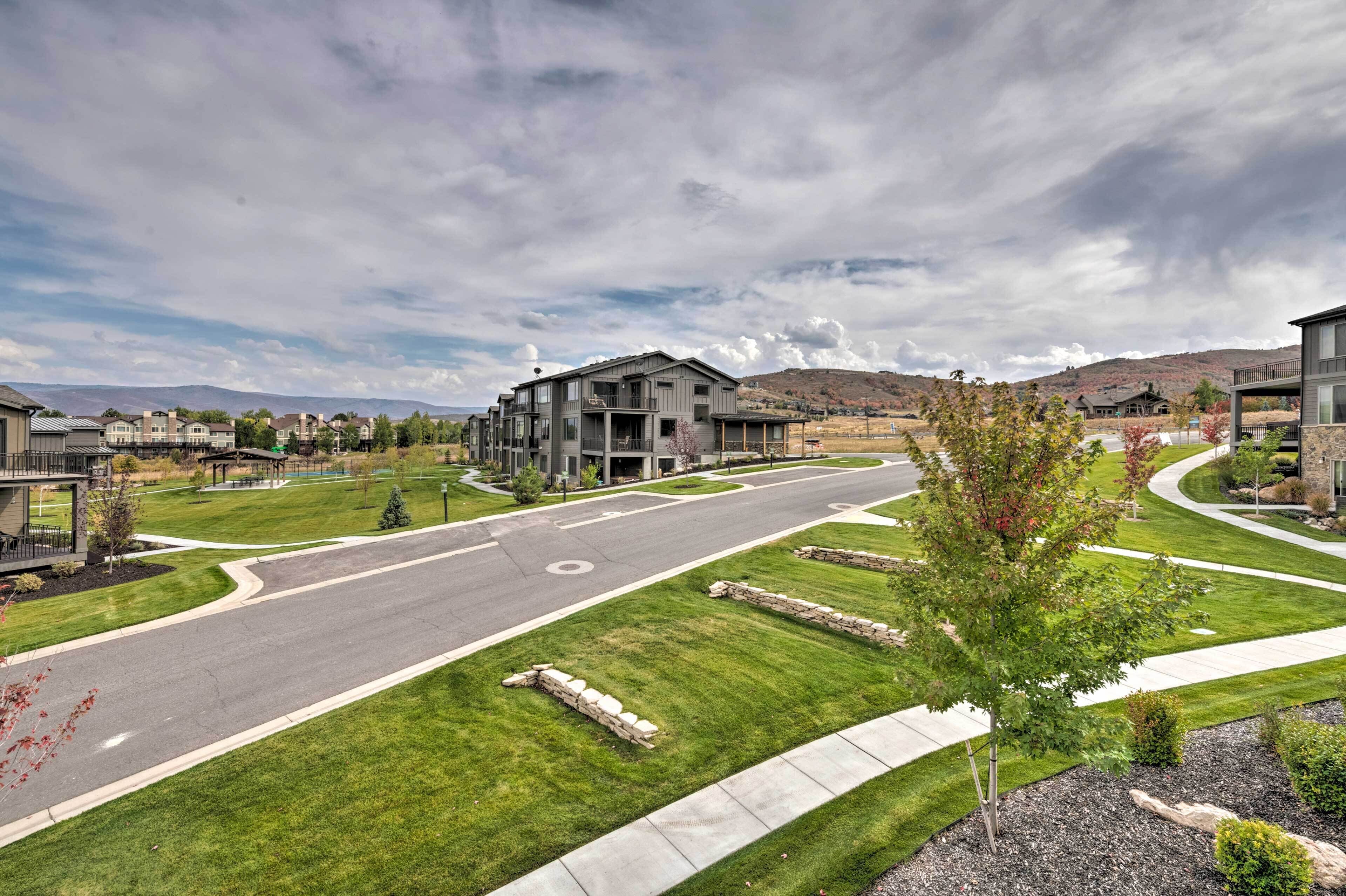 A residential area with modern houses, a well-maintained lawn, and a curved road.