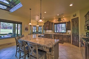 A spacious kitchen with granite countertops, wooden cabinets, and a large island with seating. - Centrally Located: Lavish Pinetop Paradise! (Pinetop)