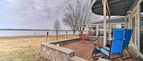 A deck with outdoor furniture overlooking a body of water.