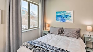 A bedroom with a bed, two bedside tables with lamps, a window with curtains, and a painting on the wall. - Anchorage Studio Escape ~ 14 Miles From Downtown! (Anchorage)