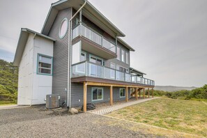 A two-story house with a covered porch and a large window on the second floor. - Oceanfront Home w/ Hot Tub, Sauna, 8 Mi to Newport (South Beach)