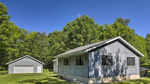 A two-story house with a garage, surrounded by lush greenery. - Cozy Florence Cabin, Proximity to Keyes Peak! (Florence)