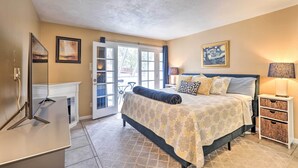 A bedroom with a bed, a TV, a fireplace, and a door leading to a balcony. - Expansive Flagstaff Family Retreat w/ Media Room! (Flagstaff)
