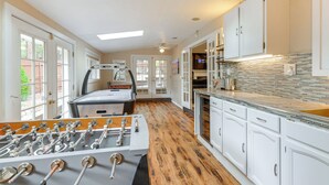 A kitchen with a foosball table, white cabinets, and a tiled backsplash. - Expansive Flagstaff Family Retreat w/ Media Room! (Flagstaff)