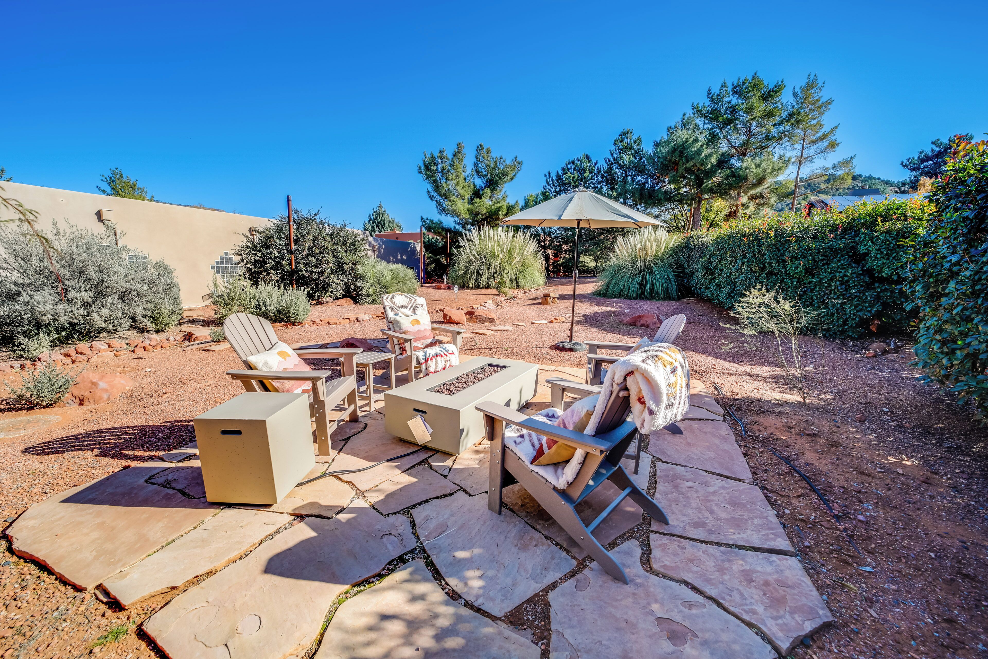 An outdoor patio with stone flooring, a fire pit, and outdoor furniture.