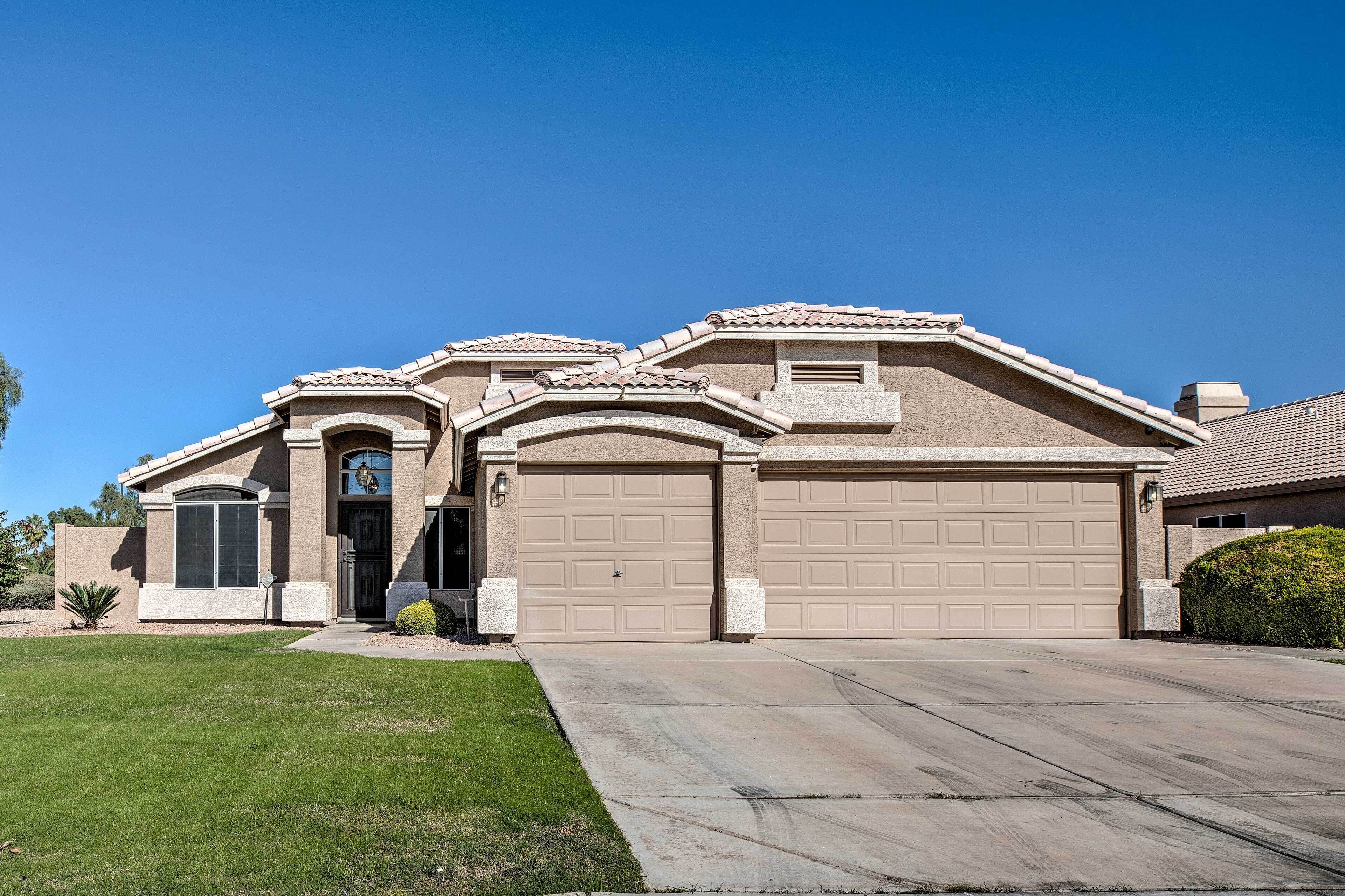 A single-story house with a beige facade, a front garage, and a well-maintained lawn.