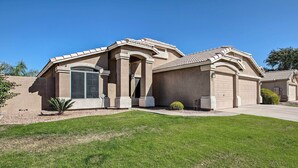 A two-story house with a large garage, a covered patio, and a well-maintained lawn. - Outdoor Kitchen, Heated Pool: Gilbert Retreat! (Gilbert)