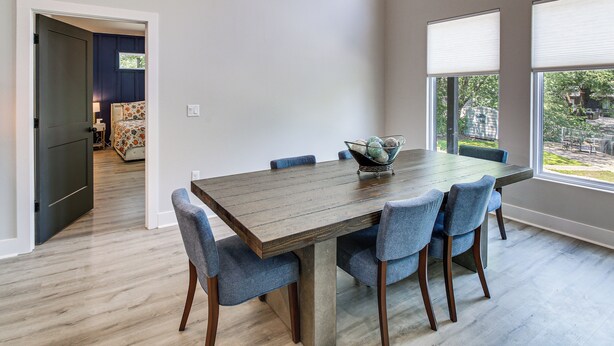 Comedor con una mesa grande, seis sillas y un tazón sobre la mesa.