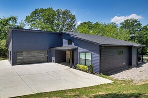 A modern two-story house with a garage, a covered driveway, and a well-maintained lawn. - Lakefront Hot Springs Home w/ Private Dock (Hot Springs)
