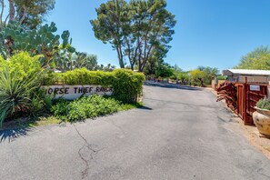 A paved road leading to a building with a sign reading 'HORSE THIEF RANCH.'