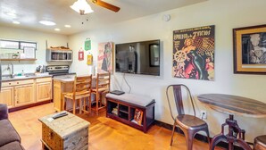 A kitchen with wooden cabinets, a microwave, a stove, and a ceiling fan.