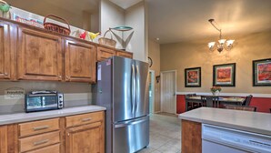 A kitchen with wooden cabinets, a stainless steel refrigerator, a dishwasher, and a microwave. - Arizona Home w/ Patio, Fire Pit & Gas Grill (Williams)