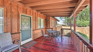A wooden deck with a red floor, a table with chairs, and a bench. - Quaint Sedona Cottage w/ Backyard + Views! (Sedona)