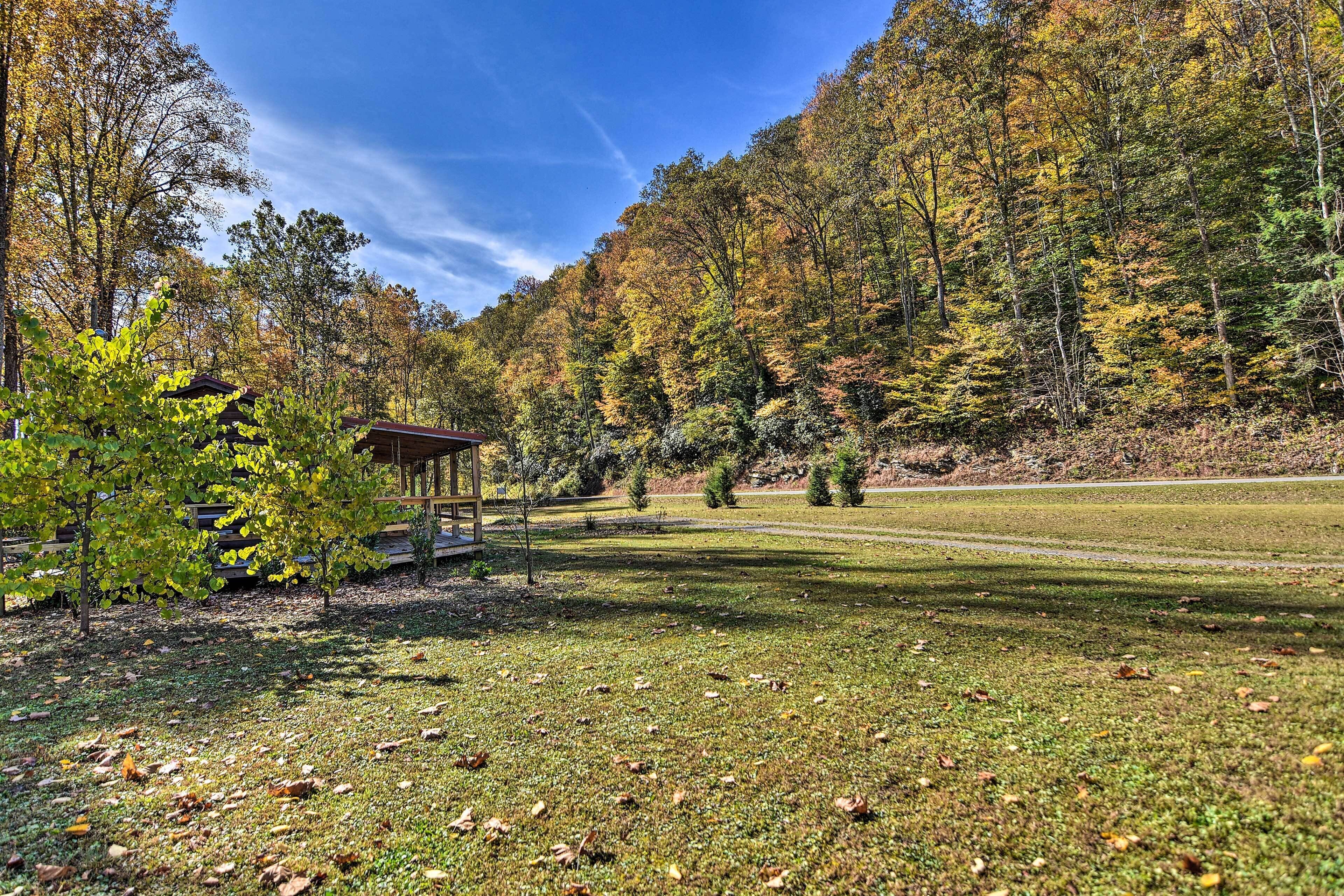 A park with a gazebo, grassy areas, and trees with autumn foliage.