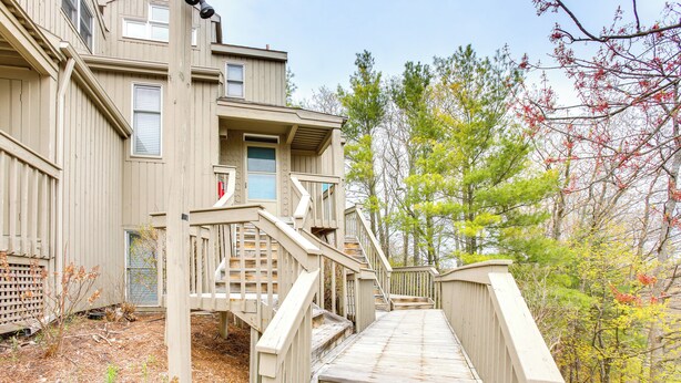 A wooden staircase leading to a building with multiple windows and a door. - Glen Arbor Vacation Rental w/ Views of Lake! (Glen Arbor)