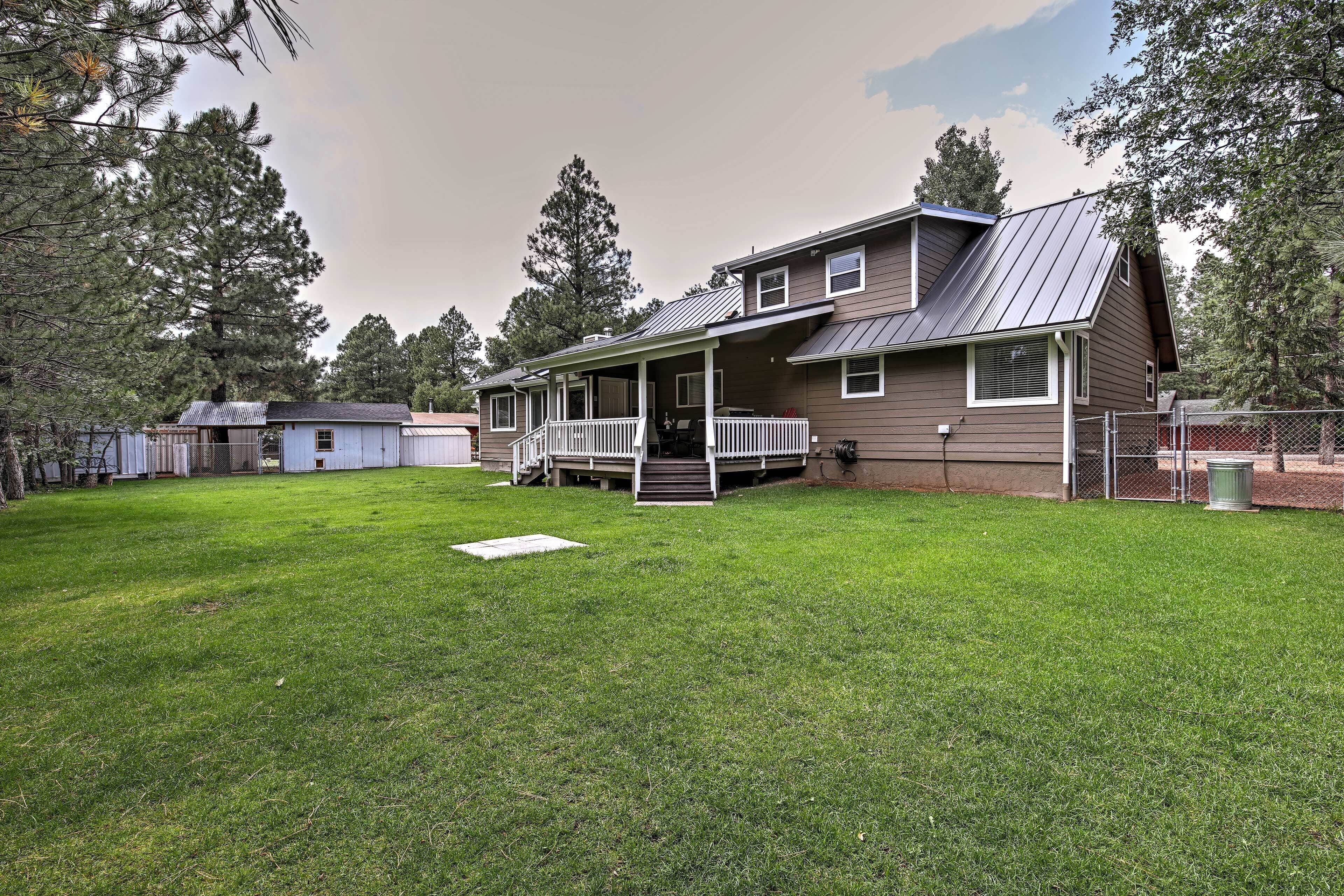 A two-story house with a covered porch and a fenced yard.
