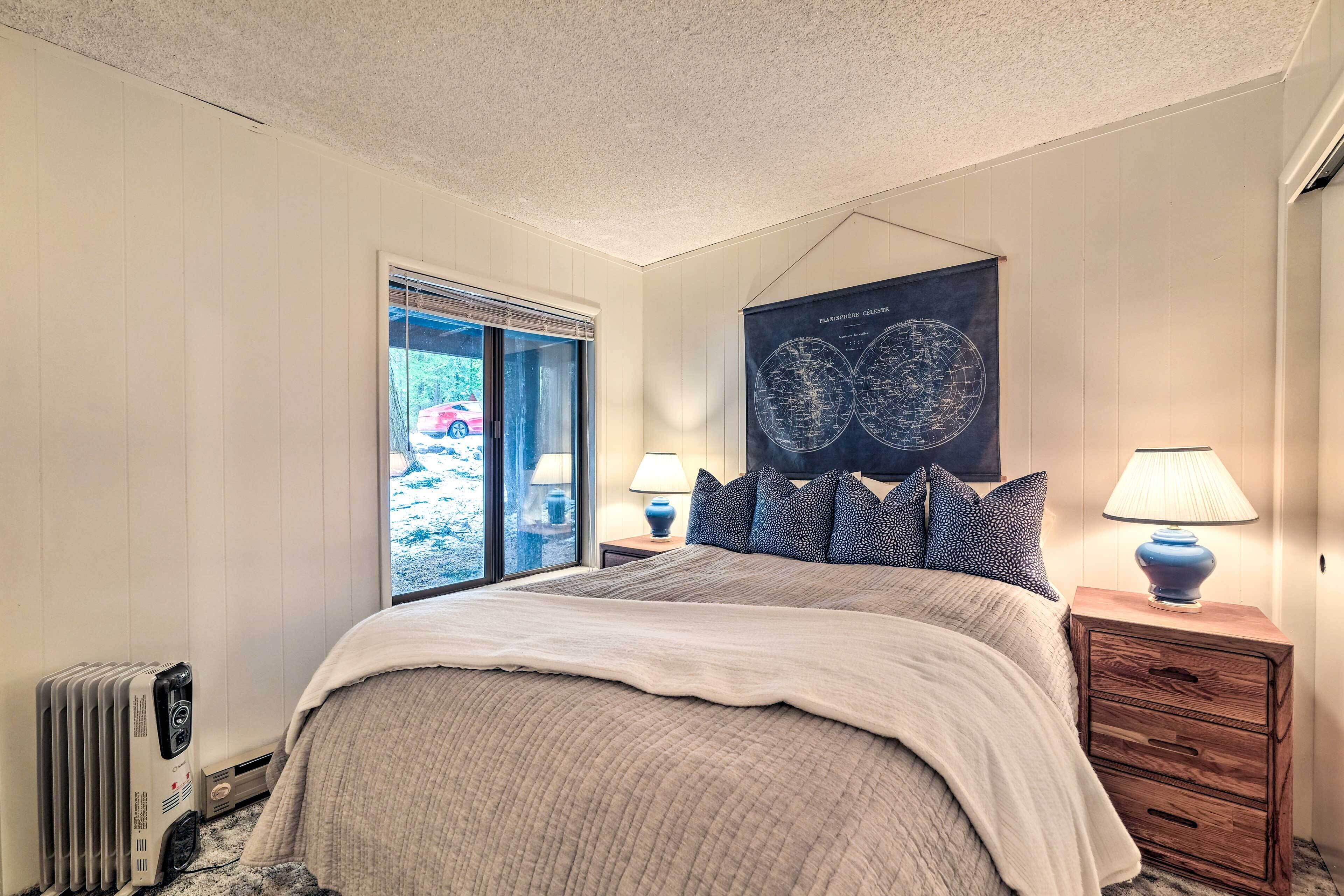 A bedroom with a bed, two bedside lamps, a radiator, a window with blinds, and a wall-mounted globe.