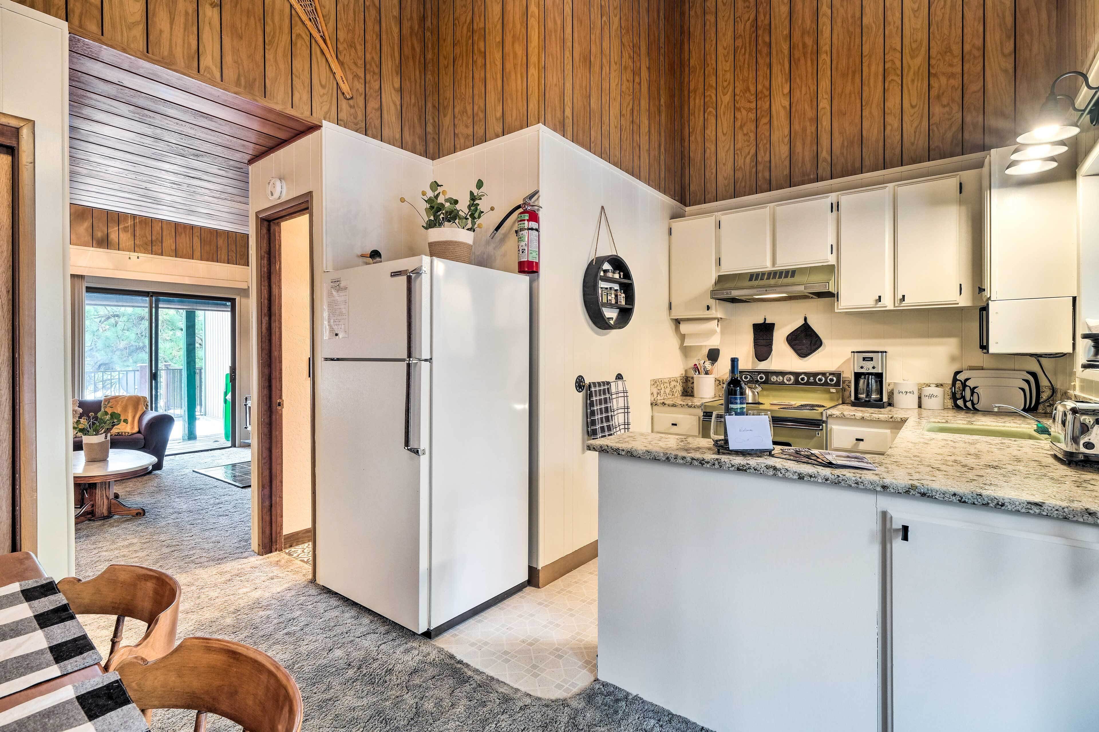 A modern kitchen with white cabinets, a granite countertop, and a built-in oven.