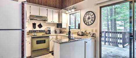 A kitchen with a built-in oven, microwave, and a large island with a sink.