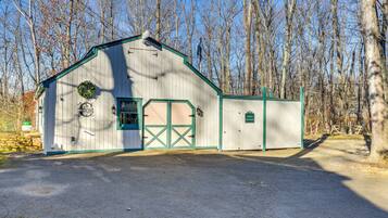 Set amidst leafless trees, this charming barn-style building offers a serene country retreat.
