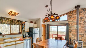 A kitchen with a wooden table, chairs, a stove, and a sink.