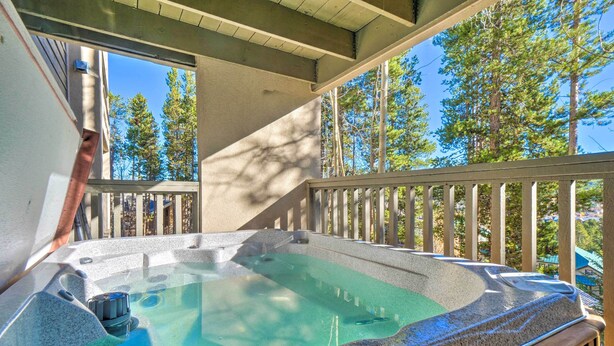 A hot tub on a balcony with a view of trees and a building in the background. - Walk to Lifts: 'chimney Ridge' Townhome w/ Hot Tub (Breckenridge)