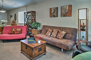 Ein Wohnzimmer mit einem braunen Sofa, einem roten Sofa, einem Holztisch und einem Bücherregal.