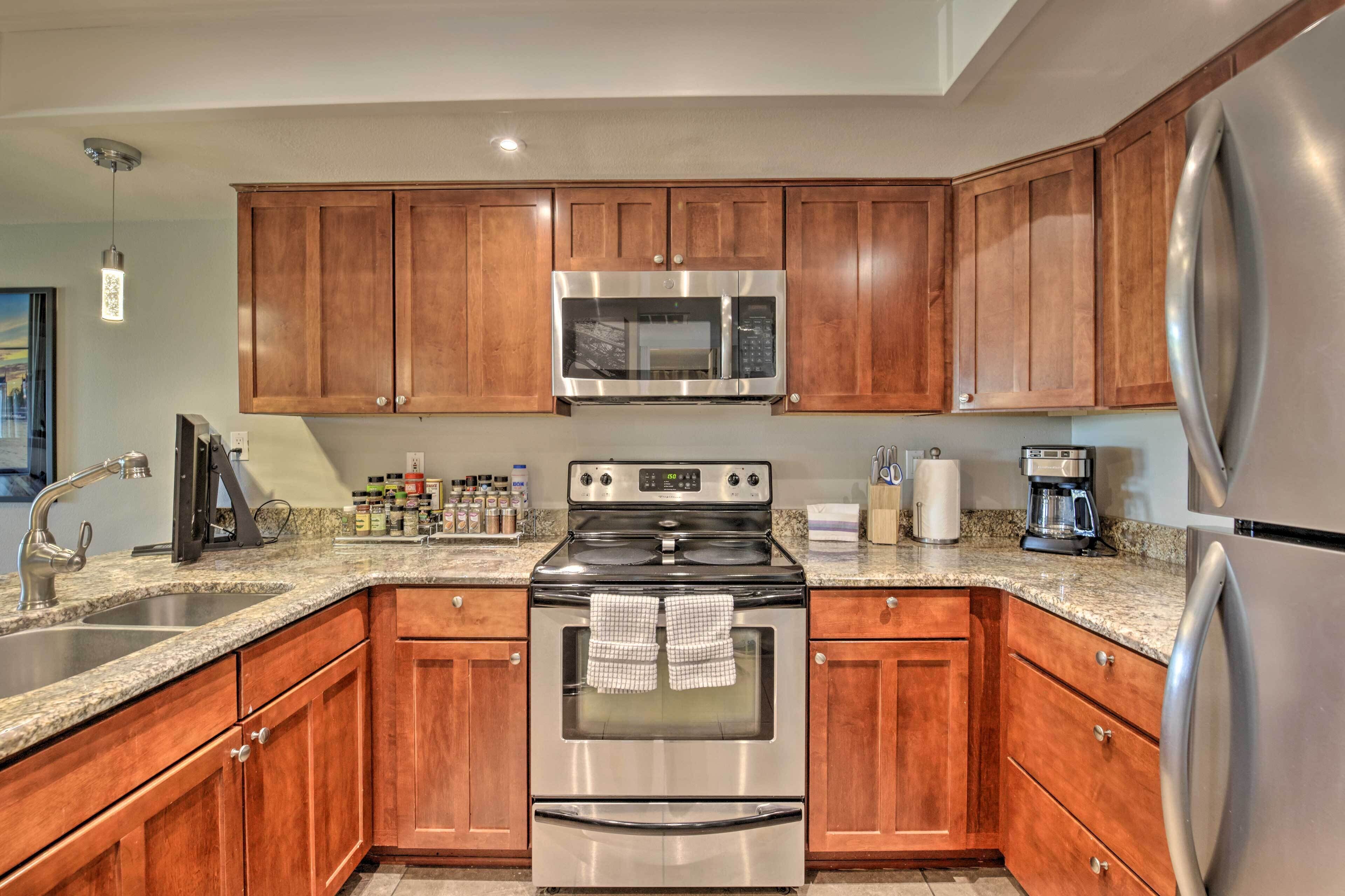A kitchen with wooden cabinets, stainless steel appliances, granite countertops, and a built-in oven.