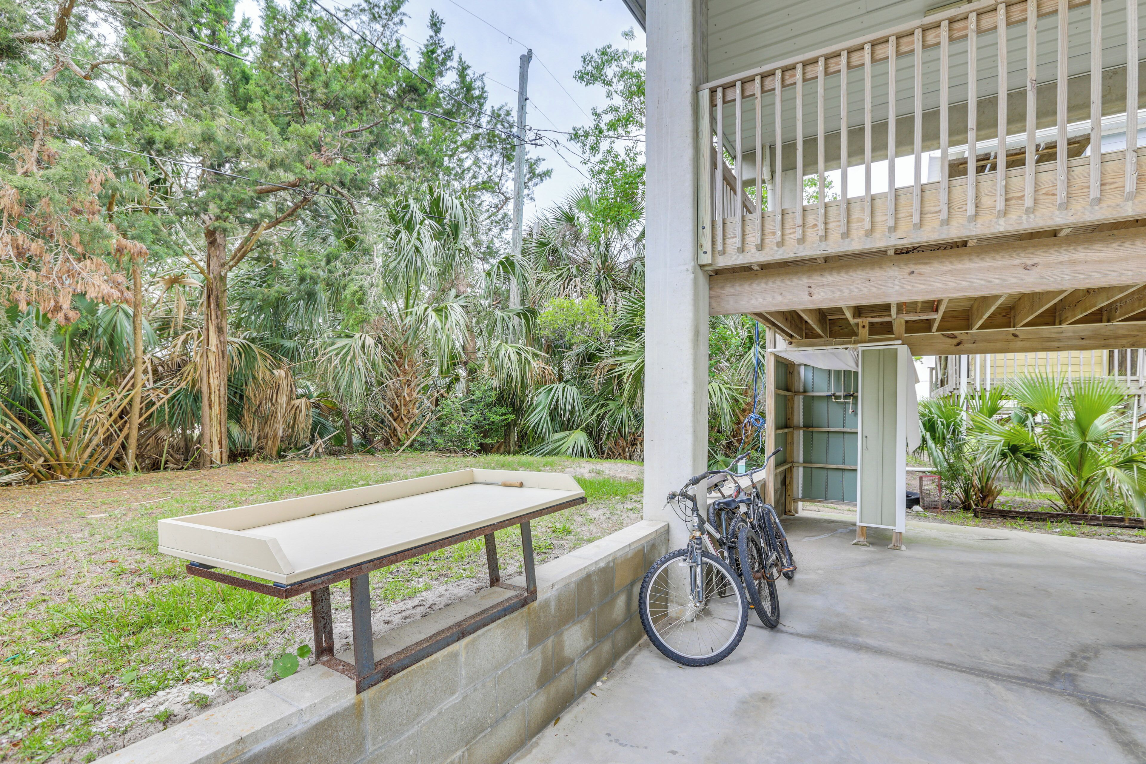 A concrete bench, a bicycle, and a building with a balcony.