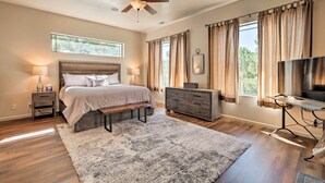 A bedroom with a bed, bedside tables, a dresser, a TV, and a ceiling fan. - Wooded Patio Oasis! Group Getaway in Flagstaff (Flagstaff)