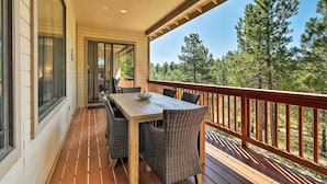 A wooden deck with a table and chairs, overlooking a forested area. - Wooded Patio Oasis! Group Getaway in Flagstaff (Flagstaff)