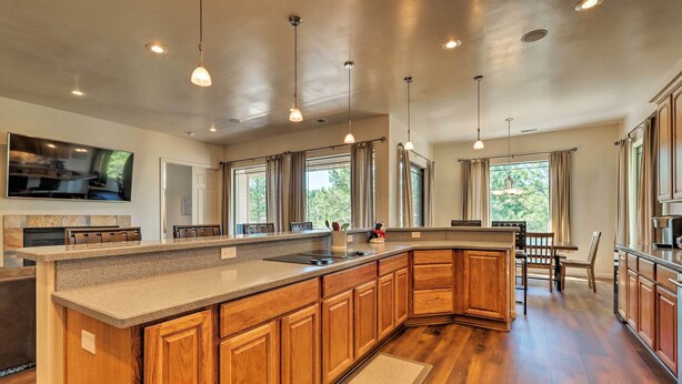 A spacious kitchen with a large island, wooden cabinets, and pendant lighting. - Wooded Patio Oasis! Group Getaway in Flagstaff (Flagstaff)