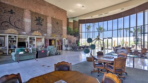 A spacious lobby with a large dining area, a fireplace, and a staircase leading to an upper level.