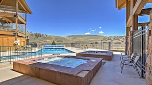 A pool area with a hot tub, outdoor seating, and a view of a mountainous landscape. - Granby Condo w/ Pool Access, Near Hiking & Skiing! (Granby)