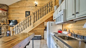 A kitchen with a wooden staircase, granite countertops, and white cabinets. - Granby Condo w/ Pool Access, Near Hiking & Skiing! (Granby)