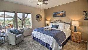 A bedroom with a bed, a chair, a nightstand, a ceiling fan, and a window with a view of the outdoors. - Oro Valley Getaway w/ Patio, BBQ & Mountain Views! (Oro Valley)