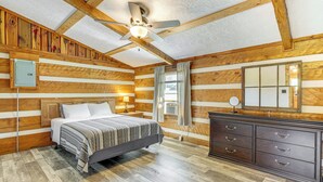 A log cabin-style bedroom with a bed, dresser, and ceiling fan. - Rogersville Barn Apartment on 27 Acres w/ Pond! (Rogersville)