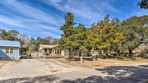 A residential area with a house, a driveway, and surrounding trees.