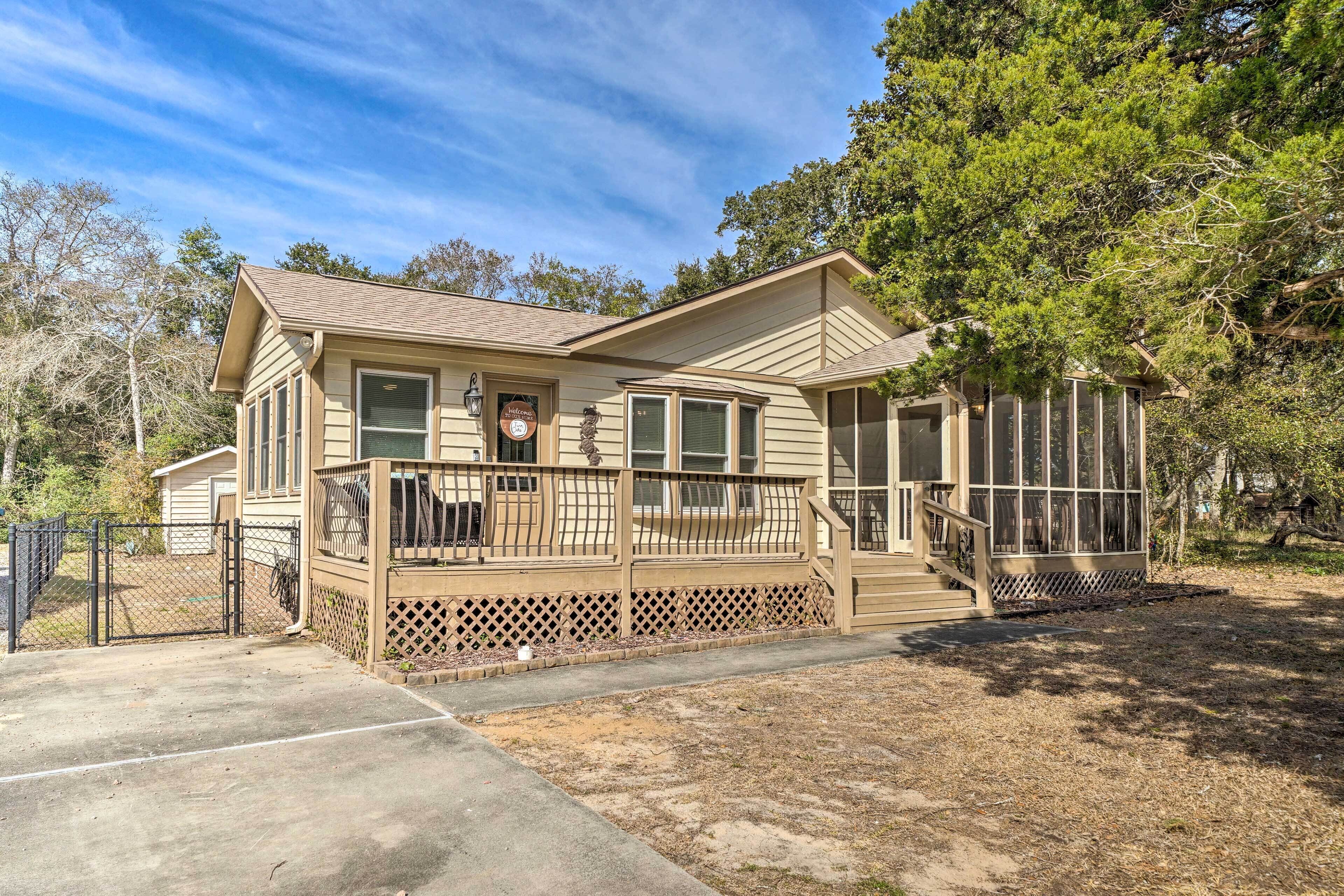 A two-story house with a front porch, a covered patio, and a fenced yard.