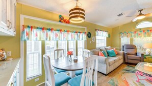 A bright living room with a dining area, a ceiling fan, and a window with a colorful curtain. - Sarasota Home w/ Full Resort Amenity Access! (Sarasota)