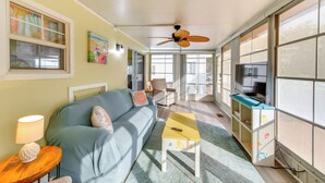A living room with a sofa, a coffee table, a TV stand, and a ceiling fan. - Sarasota Home w/ Full Resort Amenity Access! (Sarasota)