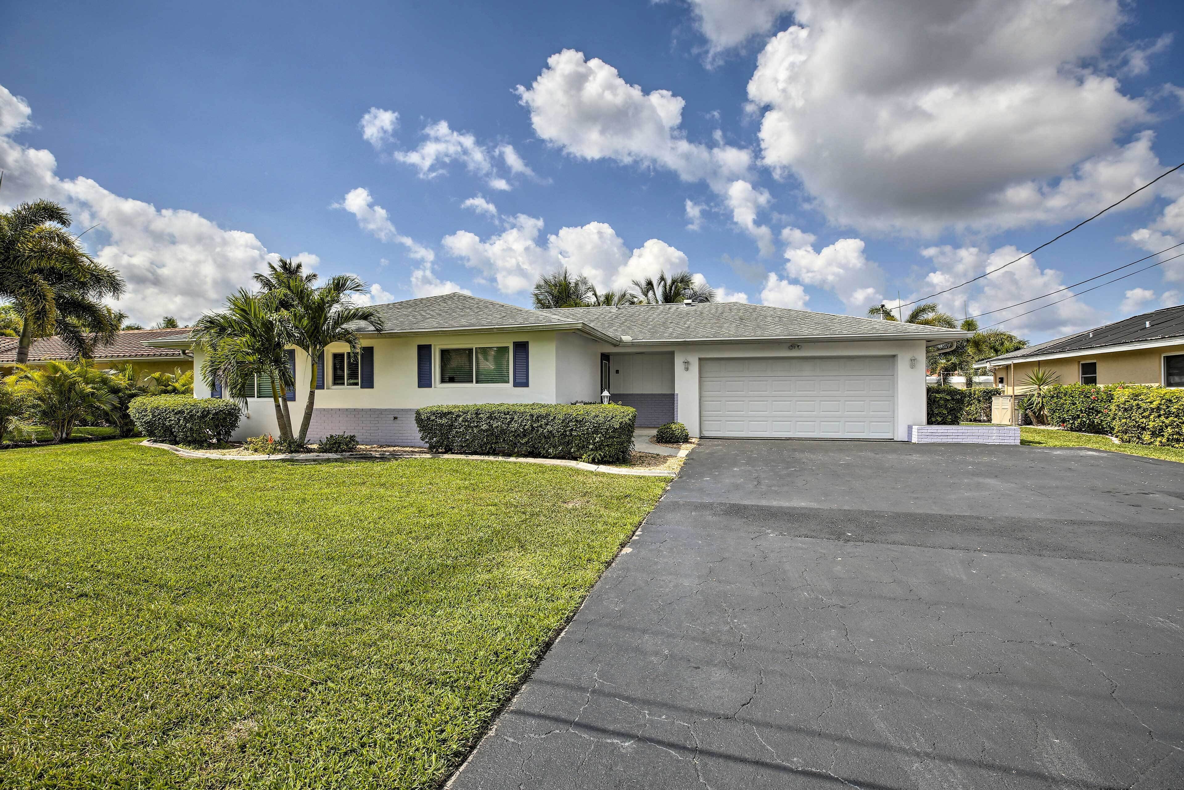 A residential house with a garage, a well-maintained lawn, and a clear sky.