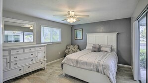 A bedroom with a bed, a dresser, a ceiling fan, and a window with blinds. - Bright Home w/ Dock & Canal View in Cape Coral! (Cape Coral)